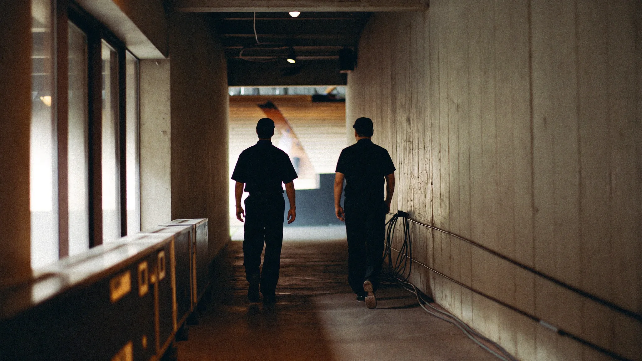 Back-of-house arena corridor with operations staff.